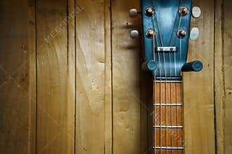 Details of an old jazz guitar on a wooden wall