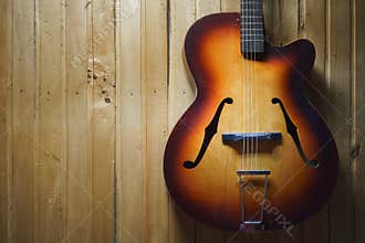 Details of an old jazz guitar on a wooden wall