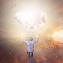 Man worshiping God. Hands with light coming from the sky