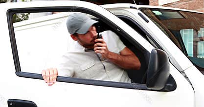 Delivery driver talking on walkie talkie and getting into van