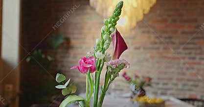 a beautiful delicate bouquet of flowers on the table in the restaurant, a beautiful chandelier, brick walls, decorated