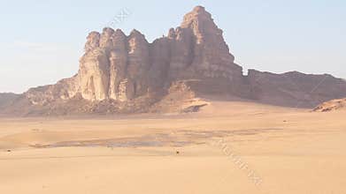 Convoy of off road vehicles crossing Wadi rum desert with dunes mountains remote transport film production logistics concept