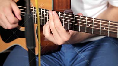 Men playing at guitar in music studio