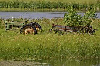 Green tractor and old manure spreader