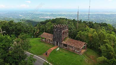 Drone view of the historic Santa Ana Stone Tower standing atop a lush, green hill
