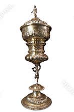 Ornate trophy featuring intricate designs and a decorative figure, crafted in shining metal