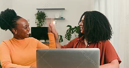 Happy Diverse Women Collaborate on Tech Project, Celebrating Success with a High Five
