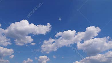 Expansive blue sky filled with fluffy white clouds, showcasing the gradual movement and transformation of cloud formations in a