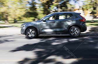 Modern SUV driving fast on a city street with motion blur background