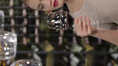 Elegant young woman savoring red wine in a chic wine cellar