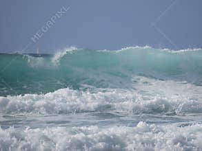 Stormy waves and a sailboat on the horizon