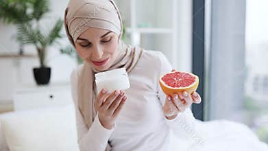 Muslim woman enjoying skincare routine with yogurt and fresh grapefruit