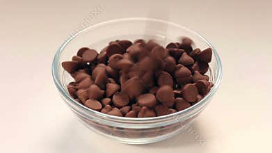 Chocolate chips pouring into bowl.