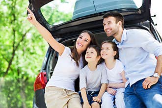 Family of four sitting in car trunk
