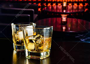 Whiskey glasses with ice in a lounge bar