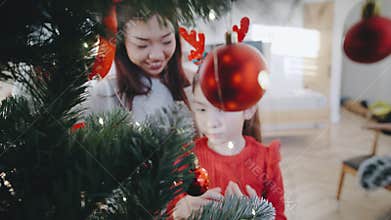Families celebrate the joy of Christmas by decorating a holiday tree together at home during the festive season