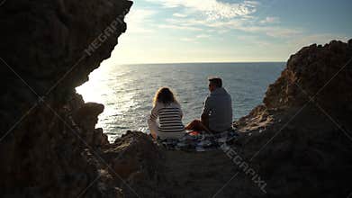 Romantic Couple Enjoys Ocean Sunset View on Rocky Cliff Vertical video