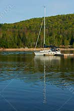 Reflection of a sailboat\'s mast near the quay