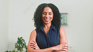 Confident Professional Business Woman Smiling with Arms Crossed in Modern Office Setting