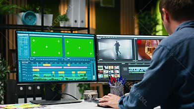 Green screen next to videographer cutting and editing video footage