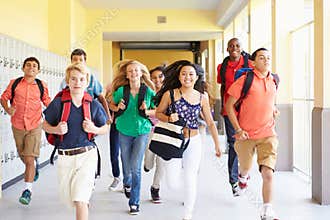 Group Of High School Students Running Along Corridor