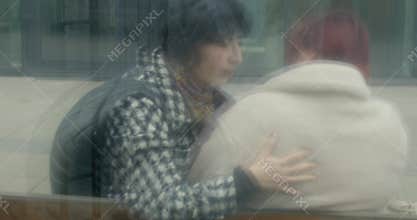 asian friend comforts white bride-to-be emotional bench hug prague