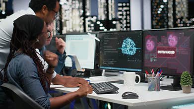 Team of programmers in office working together to block hacker intrusion