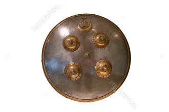 Ancient round shield displayed in a museum, showcasing intricate design and craftsmanship from historical times