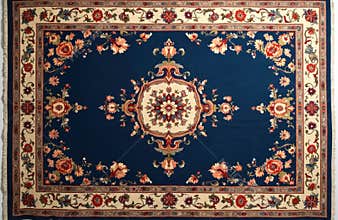 Flat lay of navy blue Persian rug with floral patterns. Intricate borders frame central medallion, soft fringe edges add texture.