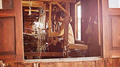 Old weaving factory. A local woman has been producing of fabric on a loom