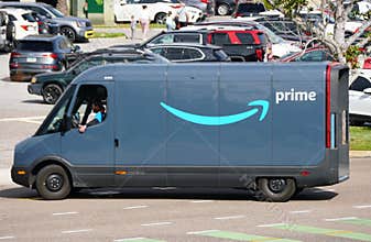 St Petersburg, Florida, U.S - Jan 3, 2026 - An Amazon Prime van navigates busy lot, showcasing modern e-commerce logistics and