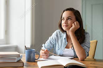 Student teenage girl studying at home daydreaming