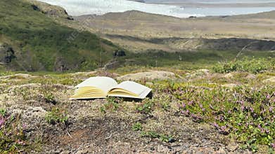 Open Sketchbook on Boulder in Expansive Green Icelandic Meadow