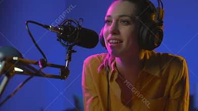 Smiling young woman working at the radio broadcasting station
