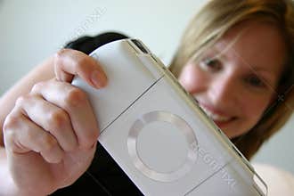 Girl smiling and playing handheld game console