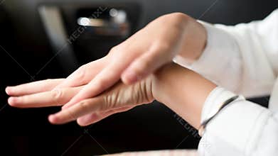 Woman using hand sanitizer in the car for hands disinfection