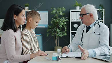 Mother and child talking to doctor during appointment in children`s hospital