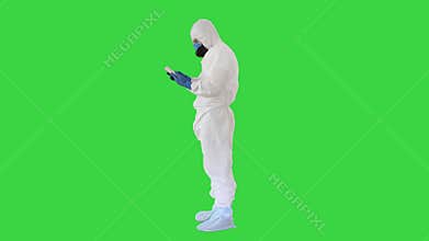 Medical Doctor in Protective Costume with Digital Tablet, Covid-19 Concept on a Green Screen, Chroma Key.