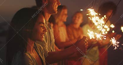 Friends playing with fire on the beach