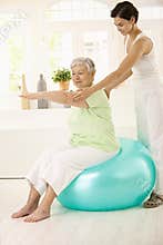 Senior woman doing fit ball exercise