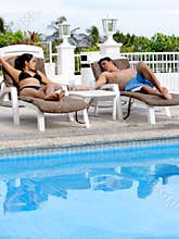 Couple in lounge chairs by the pool
