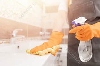 Woman disinfects surface of bathroom from viruses, germs dust and dirt. House cleaning