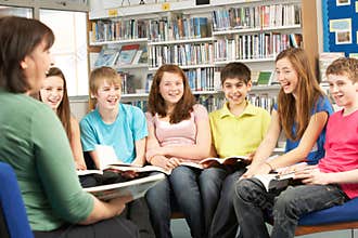 Teenage Students In Library Reading Books