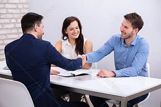 Advisor Handshaking With Couple After Deal