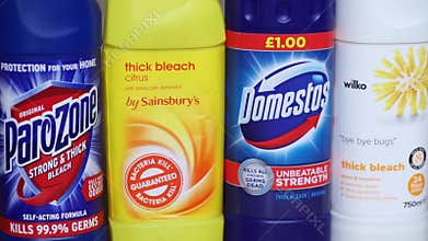 A line of various bleach bottles and labels close-up, slow pan down.