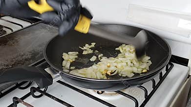 Chef mixing onion and garlic in a pan