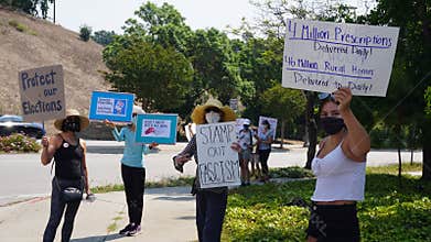Demonstrators holding signs in support of the United States Postal Service