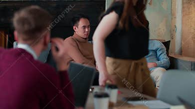 Healthy office workplace atmosphere. Two young multiethnic male business people casually chat on couch at coworking.