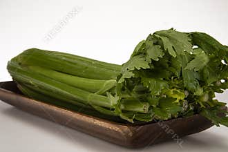 A bunch of celery in a walnut tray