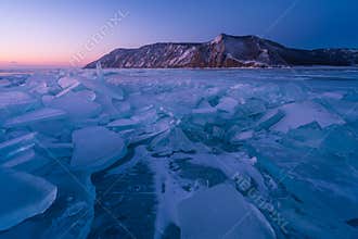 Forzen lake Baikal in winter season at sunrise view from Uzury bay, crack on smooth surface of ice, Siberia, Russia